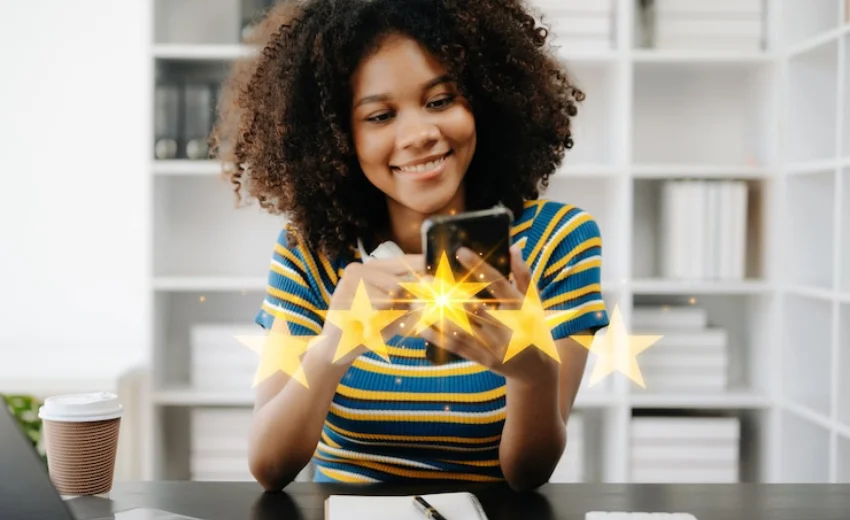 Una ragazza soddisfatta sta valutando 5 stelle il valore di un prodotto. L'immagine è all'interno di un ufficio luminoso con sfondo bianco,