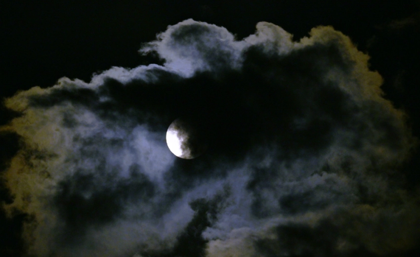 Una luna nascosta dalle nuvole crea un contrasto di chiaro e scuro simboleggiando la leadership con una visione a lungo termine.